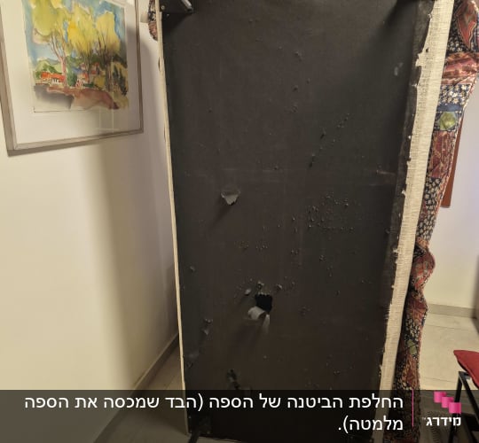 מסגרת עם בד קרוע על רצפה ליד תמונה על הקיר